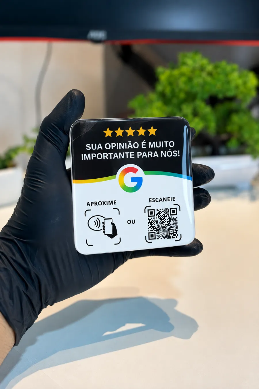 Plaquinha preta com NFC e QR Code na mão
